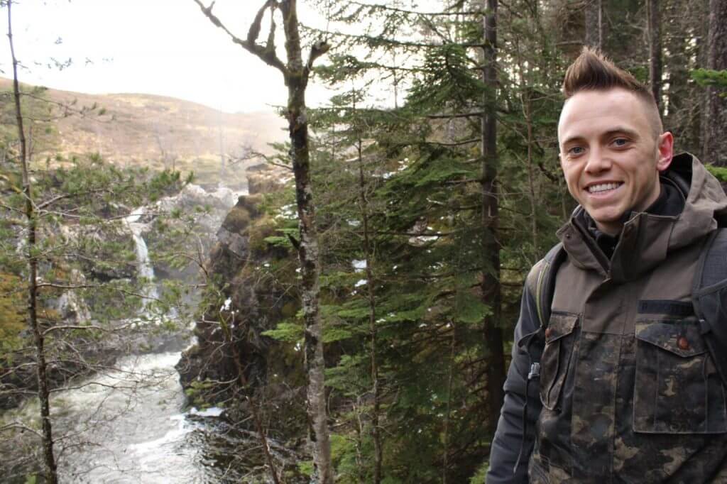 Garden Ninja Blogger smiling next to a waterfall