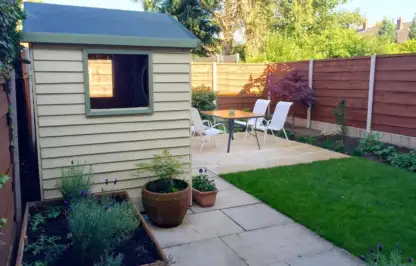 A cream shed newly laid lawn and raised bed garden makeover
