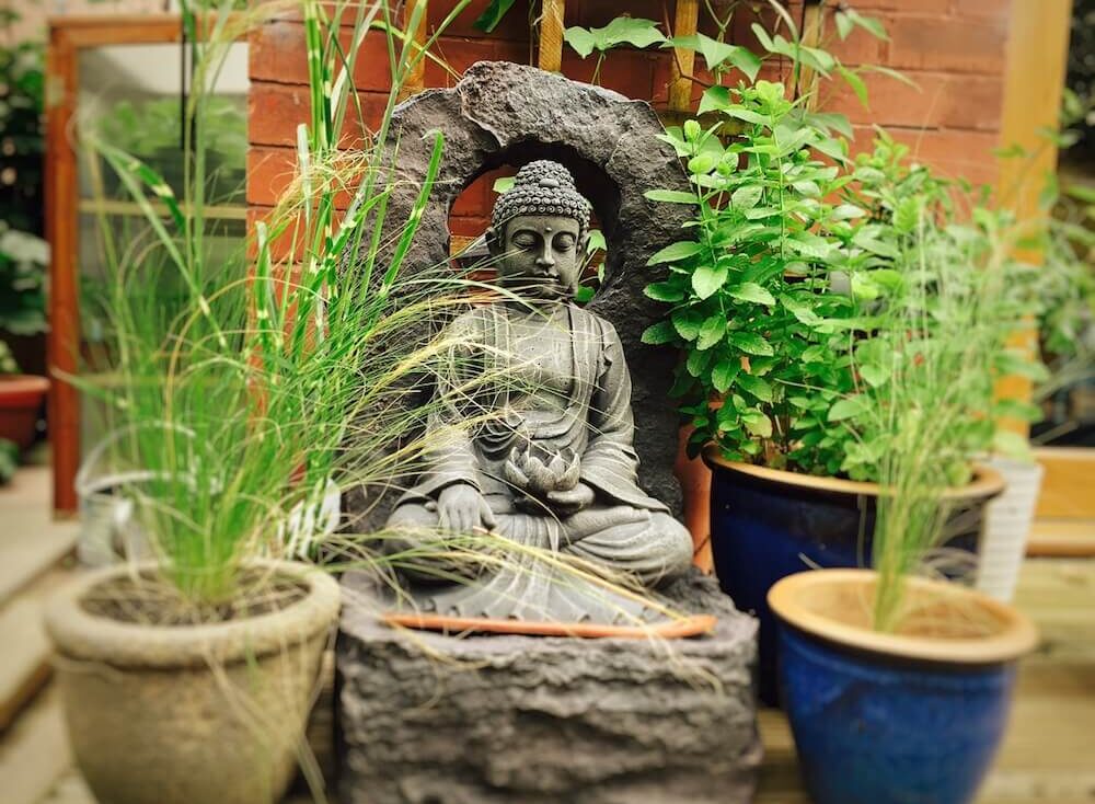 A buddha water feature in a garden