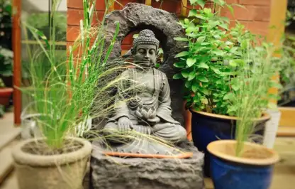 A buddha water feature in a garden