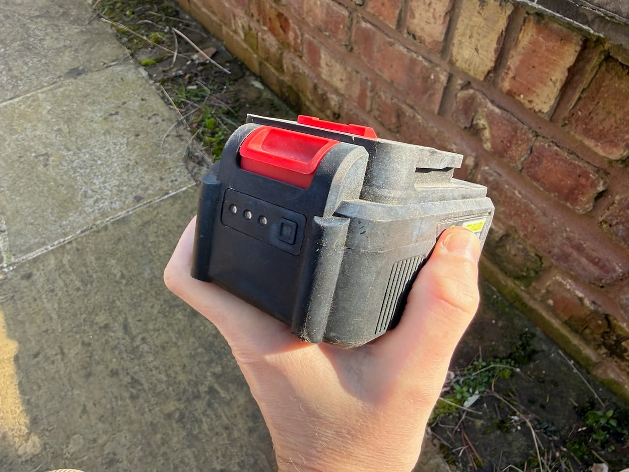 A cordless garden tool battery showing voltage and amp hour rating