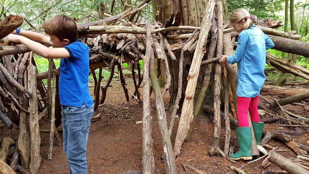 Children building a log den