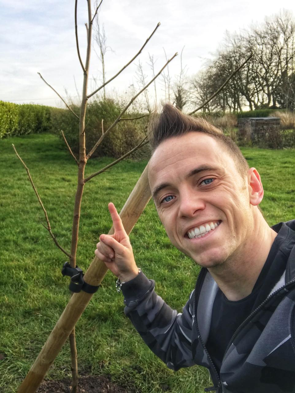 Garden Ninja next to a newly planted tree in a garden