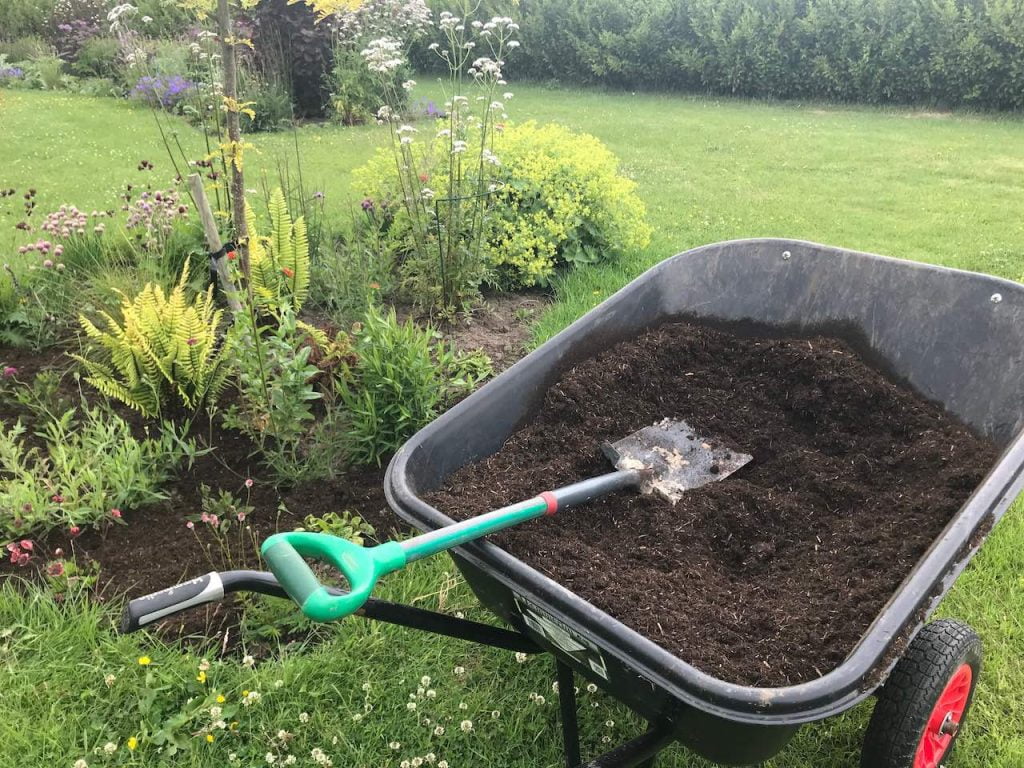 A wheel barrow full of fresh compost for mulching