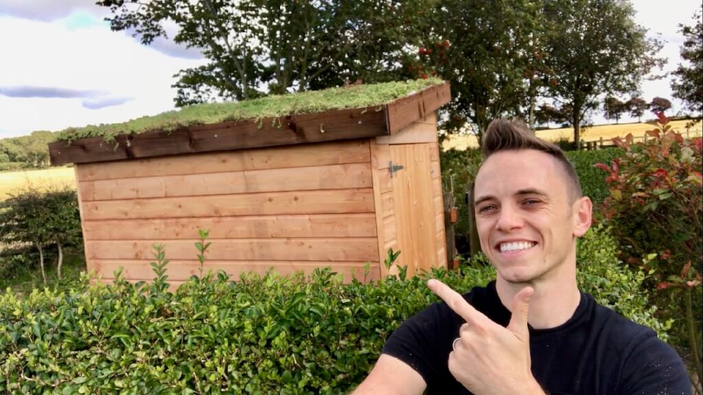 Garden Ninja multi award winning Garden Designer and blogger pointing at a green roof