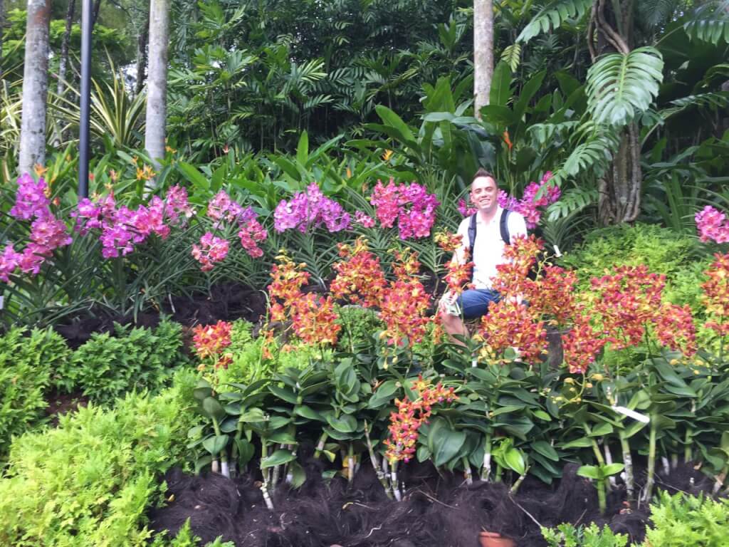 Lee Burkhill sat in a field of Orchids in Singapore