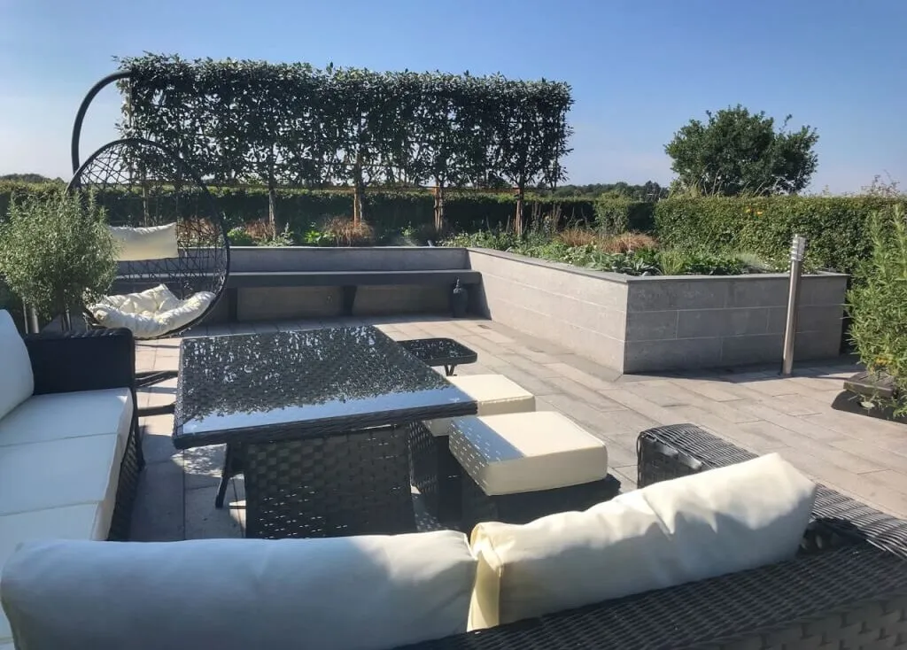 Outdoor living social garden with a white sofa by Garden Ninja