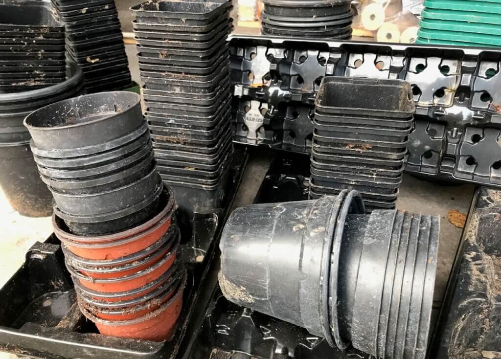 A stack of black plastic plant pots