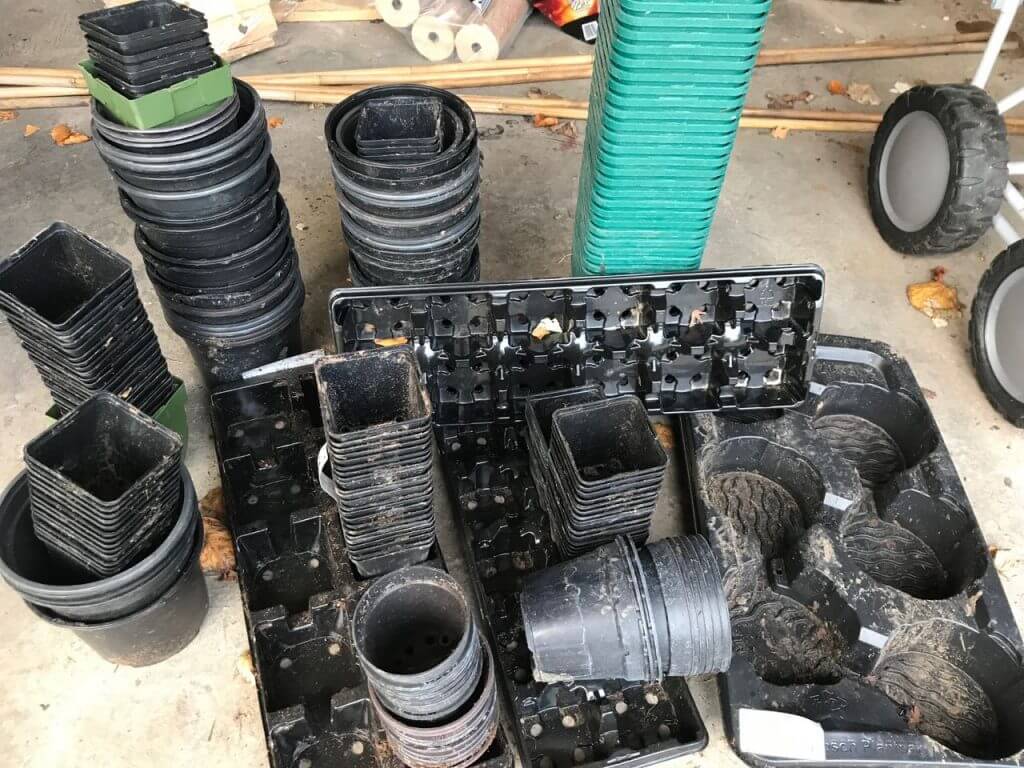 A group of plastic plant pots in a garage