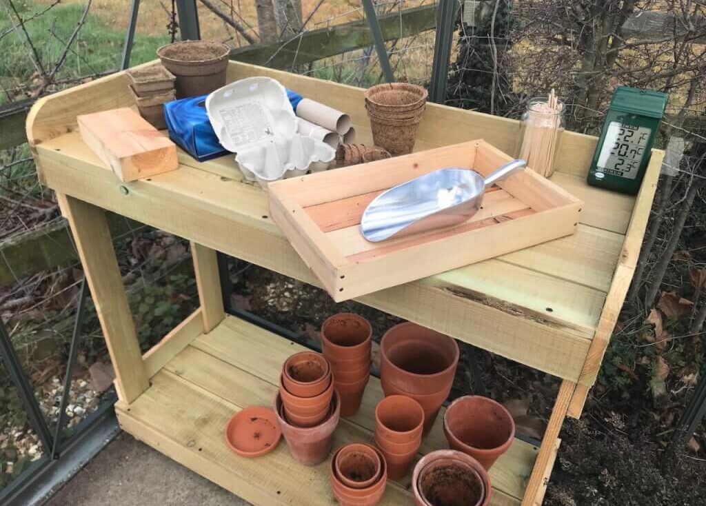 A wooden seed bench full of pots garden ninja