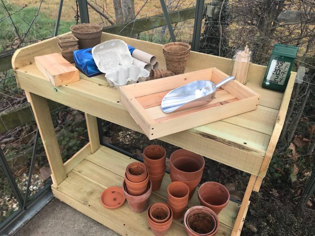 A wooden seed bench full of pots garden ninja