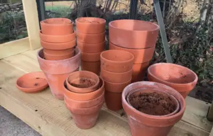 A stack of terracotta pots in garden ninjas greenhouse
