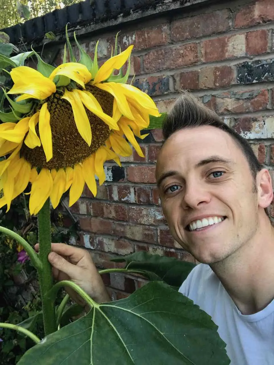 Lee Burkhill holding a sunflower at RHS Tatton