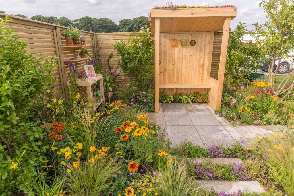 A wooden seating arbour in a show garden