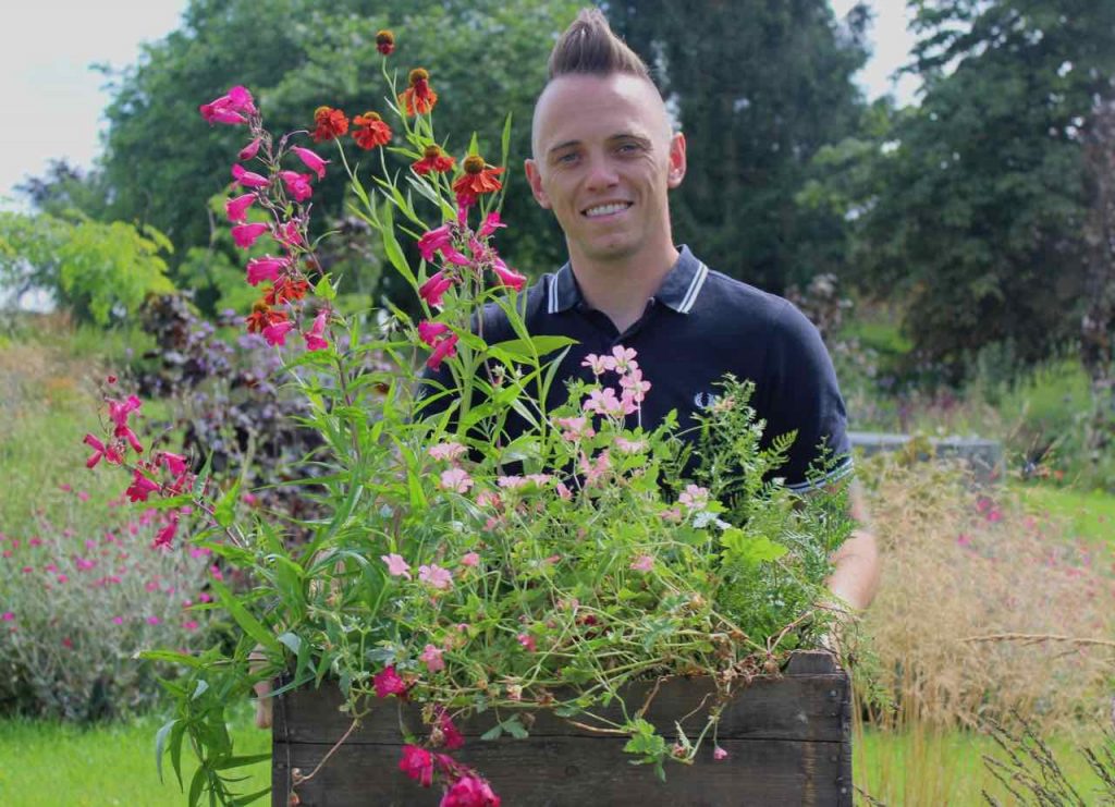 Garden Ninja holding flowers and smiling