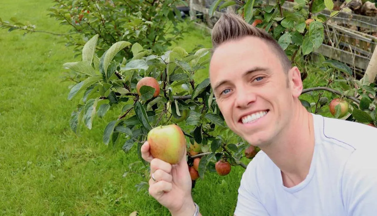 Garden Ninja smiling holding an apple