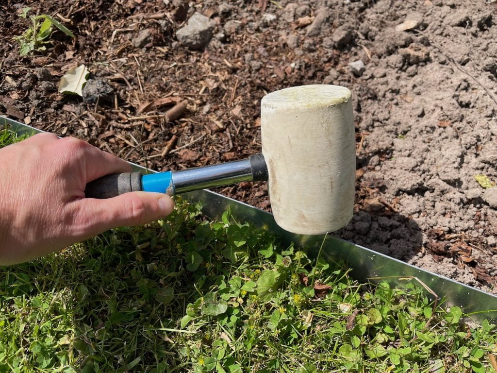 Hitting lawn edging with a mallet