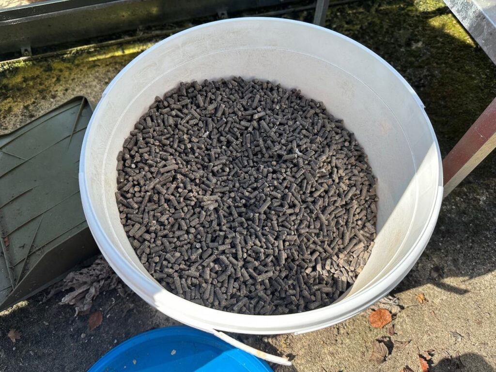 A bucket full of organic plant food pellets