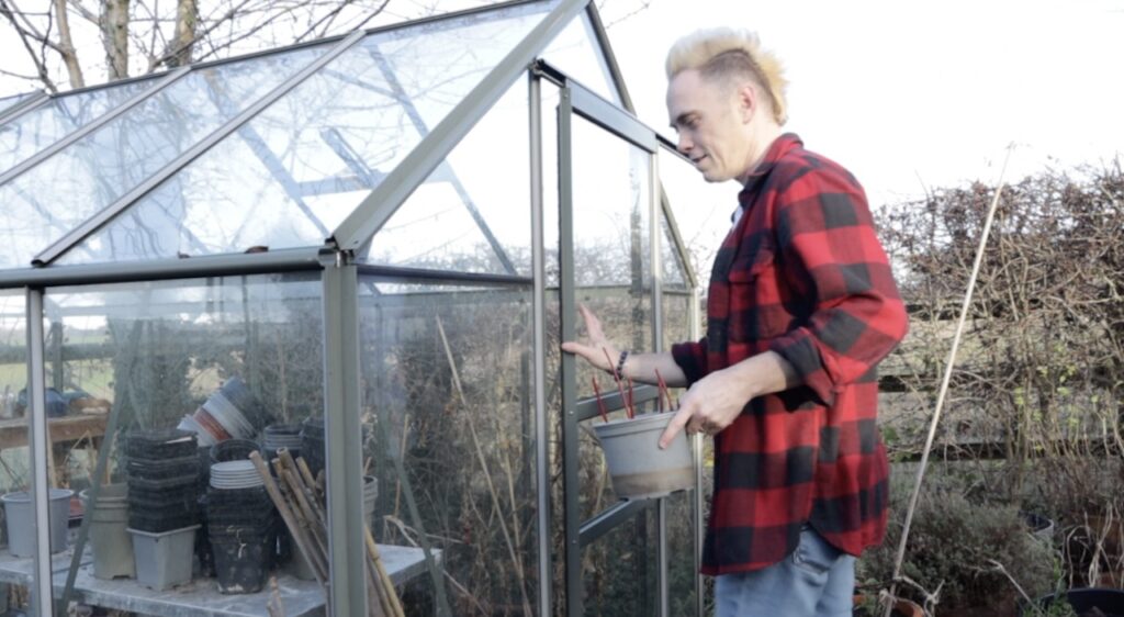 Lee Burkhill walking to a greenhouse