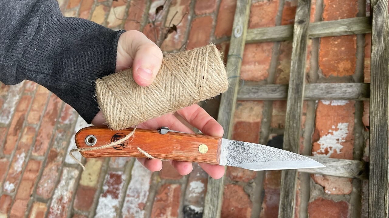 Lee Burkhill holding a pruning knife in the garden