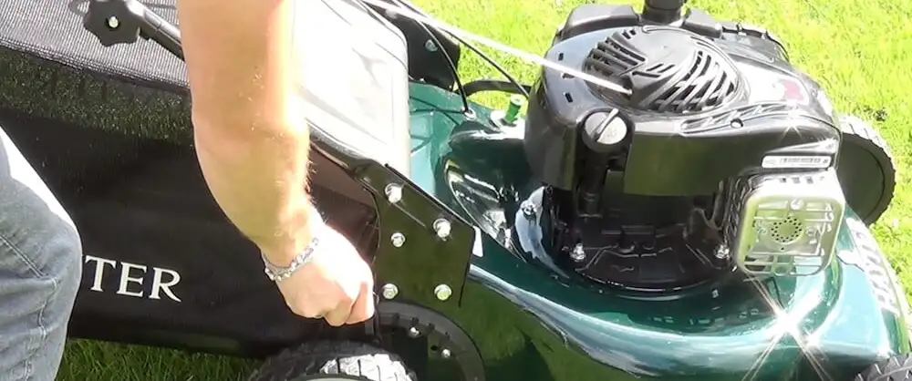 Setting a lawn mower to its highest cutting height for the first mow of new turf